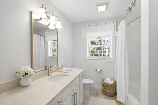 a bathroom with a sink mirror and toilet