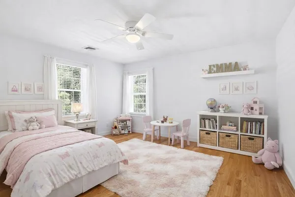 a spacious bedroom with a bed and a wooden floor