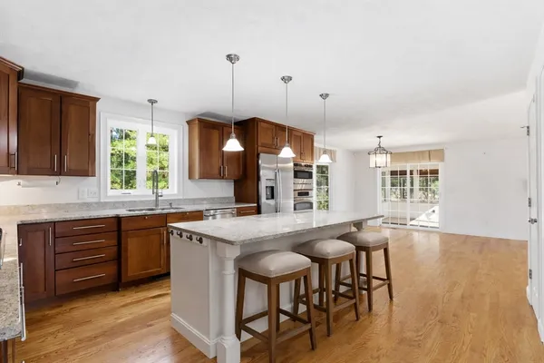 a kitchen with granite countertop a sink a center island and cabinets