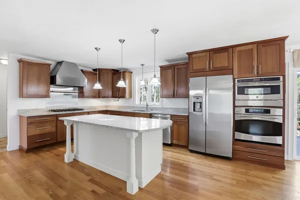 a kitchen with stainless steel appliances granite countertop a refrigerator a stove and a sink