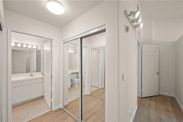 a bathroom with a glass shower door a sink and a mirror