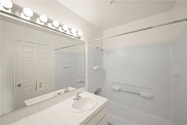 a bathroom with a sink a mirror and a shower