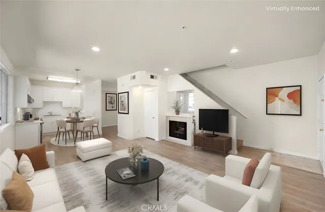a living room with furniture a flat screen tv and kitchen view
