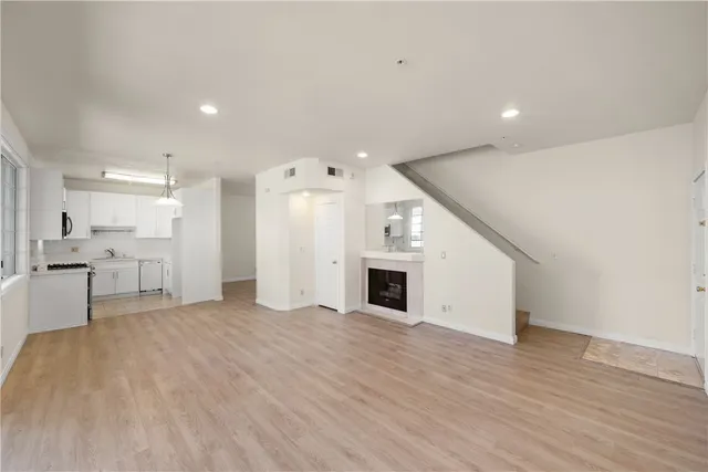 a view of a big room with wooden floor and windows