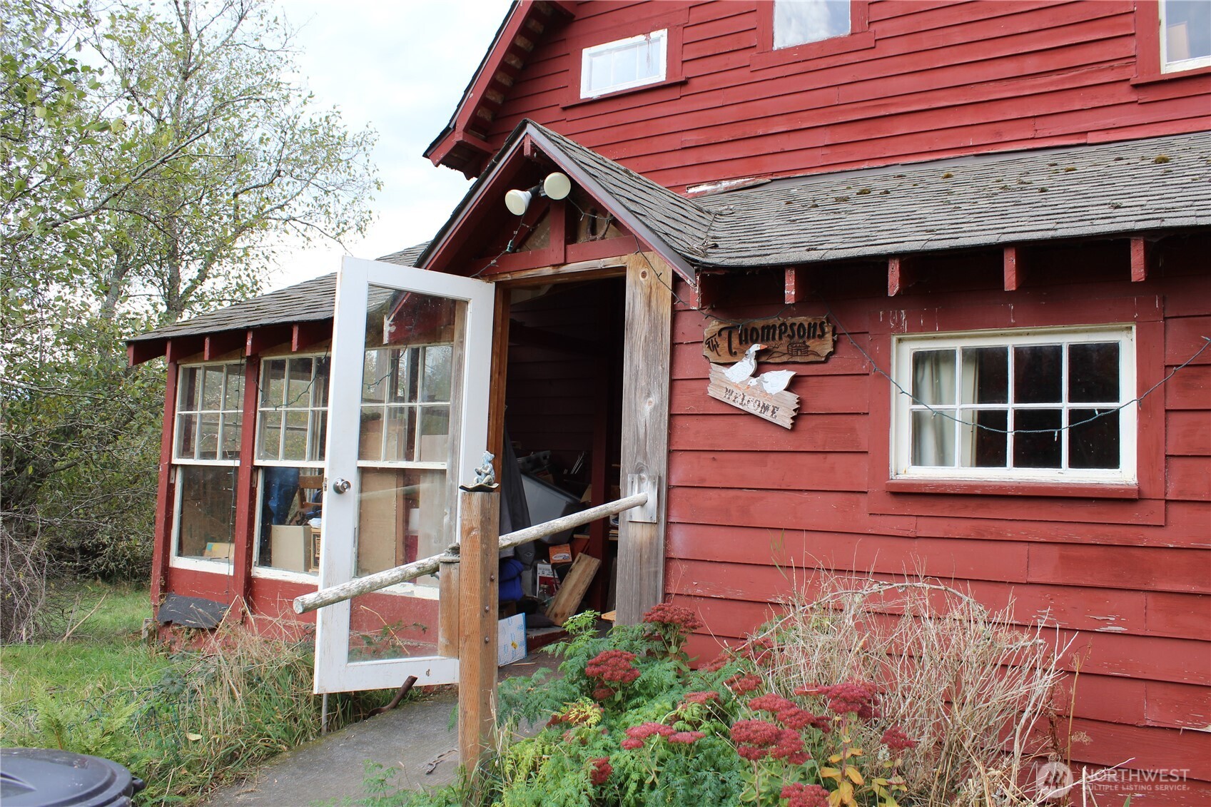 2600 Center Road Chimacum, WA 98325 - Photo 2 of 22 a view of a house with potted plants and a bench