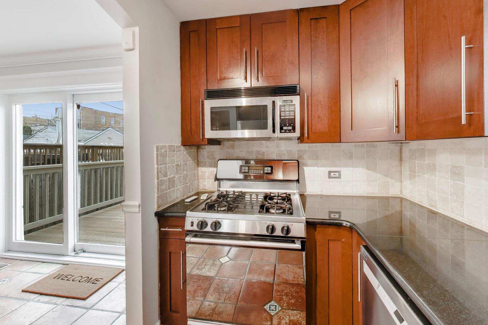 3413 South Indiana Avenue Chicago, IL 60616 - Photo 7 of 15 a kitchen with stainless steel appliances granite countertop a stove and a microwave