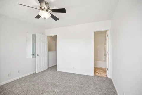 an empty room with closet and a chandelier fan