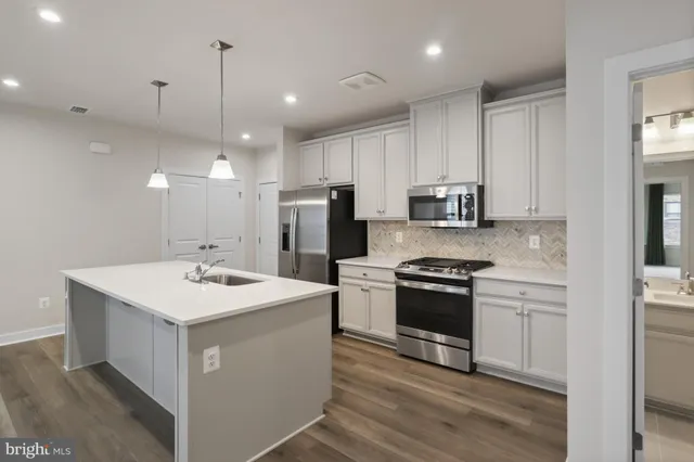 a kitchen with a sink stainless steel appliances and white cabinets