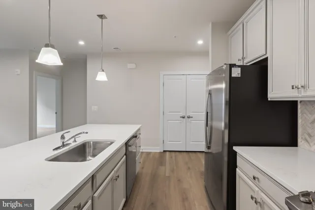 a kitchen with a sink a stove a refrigerator and cabinets