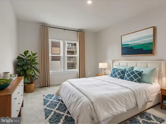 a bedroom with a bed and a potted plant