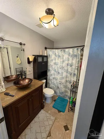 a bathroom with a granite countertop sink toilet and shower