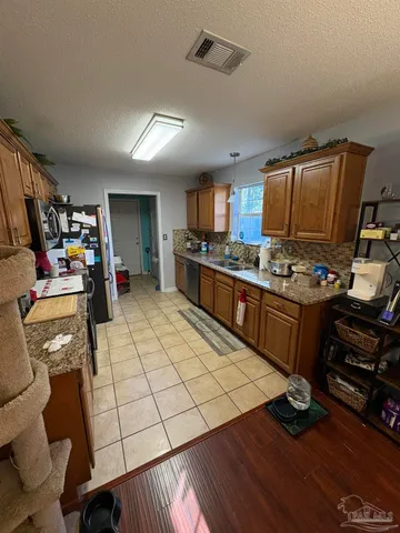 a kitchen with stainless steel appliances granite countertop a stove and a refrigerator