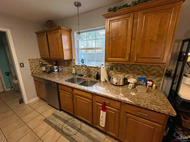 a kitchen with sink a window and wood floor