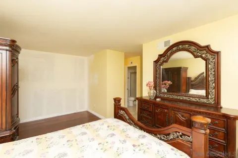 a bedroom with a bed and a dresser with mirror