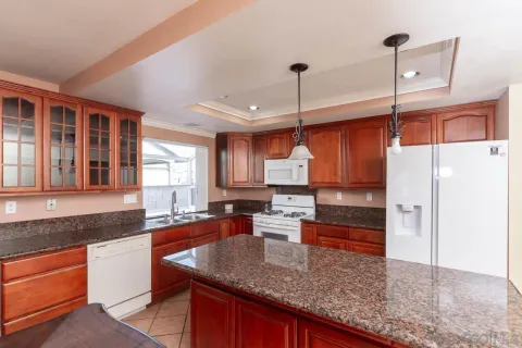 a kitchen with stainless steel appliances granite countertop a sink a counter space and a window