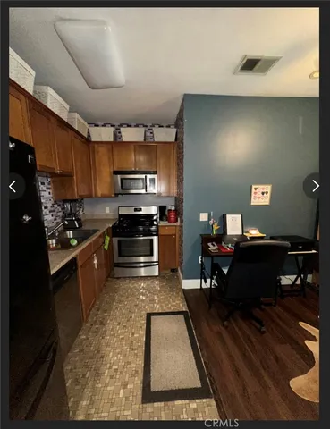 a kitchen with kitchen island granite countertop a refrigerator stove top oven and sink