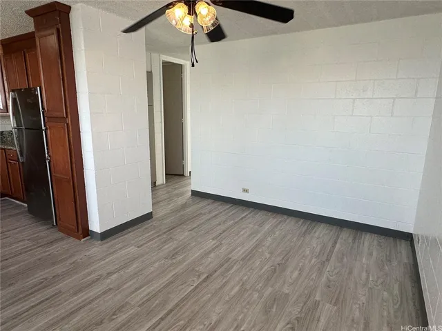 a view of a room with wooden floor a ceiling fan and window
