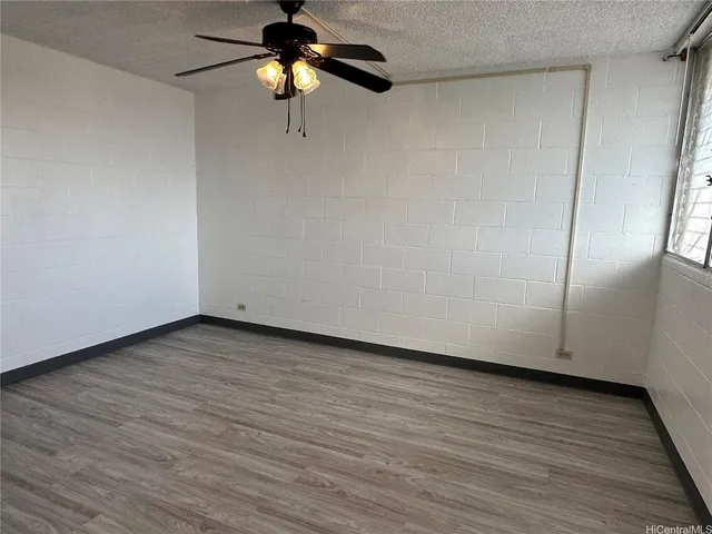 a view of a room with wooden floor and a ceiling fan