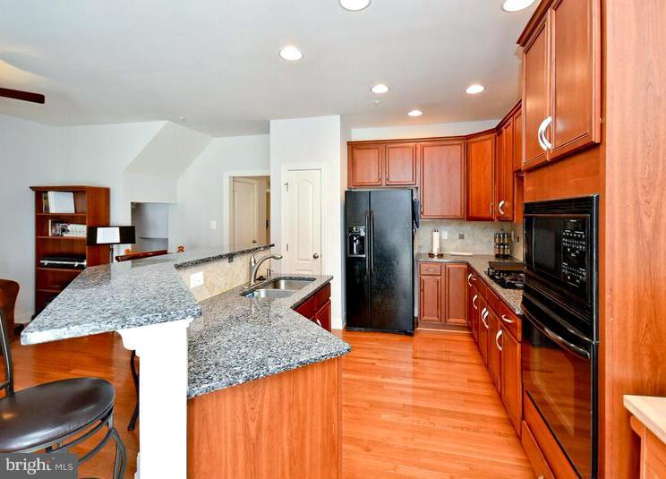 7616 Elmcrest Road Hanover, MD 21076 - Photo 3 of 30 a kitchen with stainless steel appliances granite countertop a refrigerator a stove and a sink