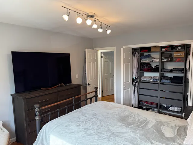 a bedroom with a bed and a flat screen tv