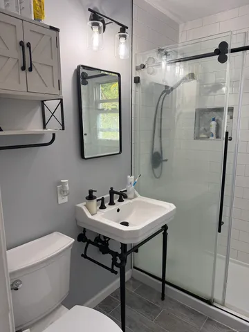 a bathroom with a toilet sink and mirror