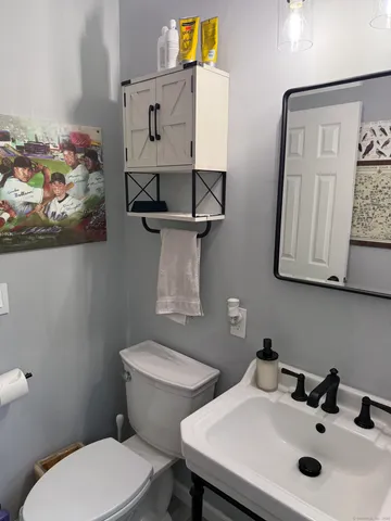 a bathroom with a toilet sink and mirror