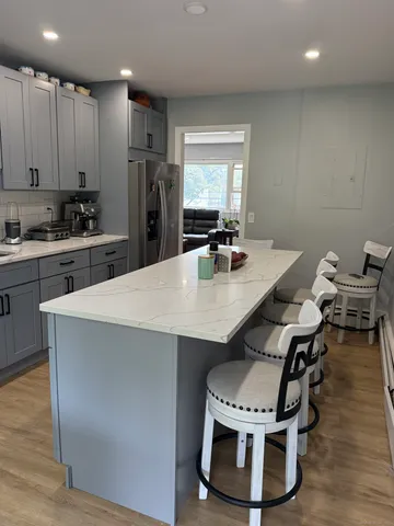 a kitchen with a dining table chairs and refrigerator