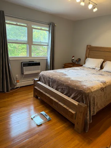 a bedroom with a bed and wooden floor