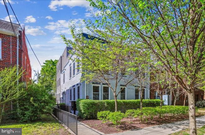 a front view of a house with plants and trees