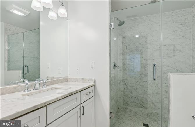 1340 Nicholson Street Northwest, Unit 2 Washington, DC 20011 - Photo 19 of 31 a bathroom with a granite countertop sink a mirror and shower