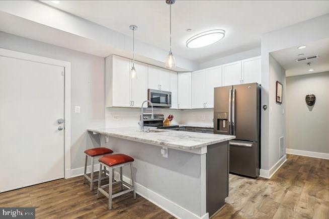1340 Nicholson Street Northwest, Unit 2 Washington, DC 20011 - Photo 5 of 31 a kitchen with stainless steel appliances granite countertop a refrigerator a stove a sink a dining table and chairs with wooden floor