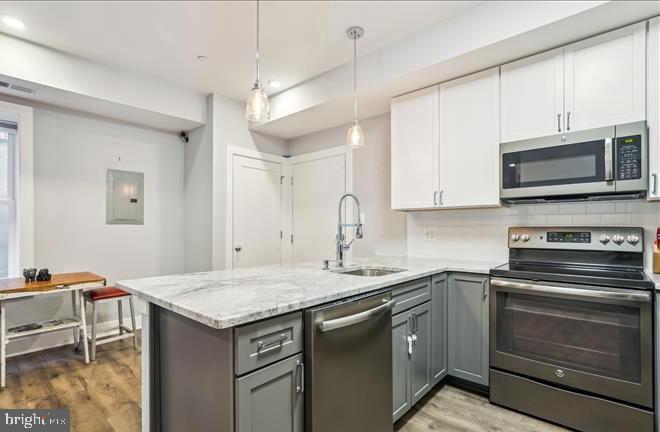 1340 Nicholson Street Northwest, Unit 2 Washington, DC 20011 - Photo 9 of 31 a kitchen with granite countertop a sink cabinets and stainless steel appliances