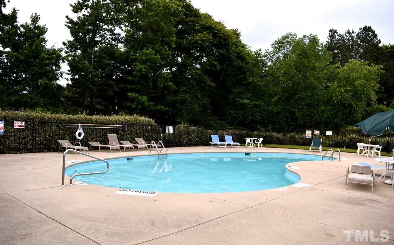 9106 Grassington Way Raleigh, NC 27615 - Photo 16 of 16 a view of a swimming pool with lawn chairs and plants