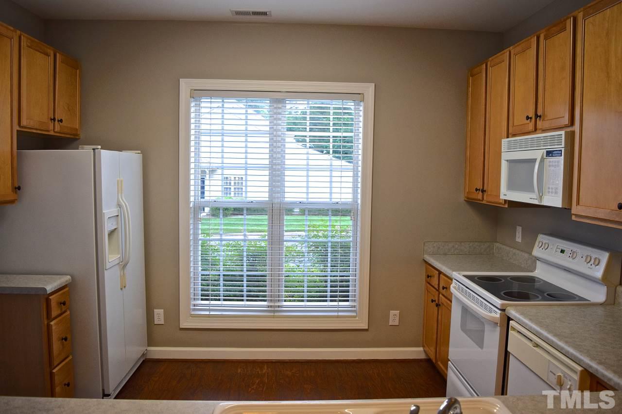 9106 Grassington Way Raleigh, NC 27615 - Photo 4 of 16 a kitchen with a stove a refrigerator and a sink