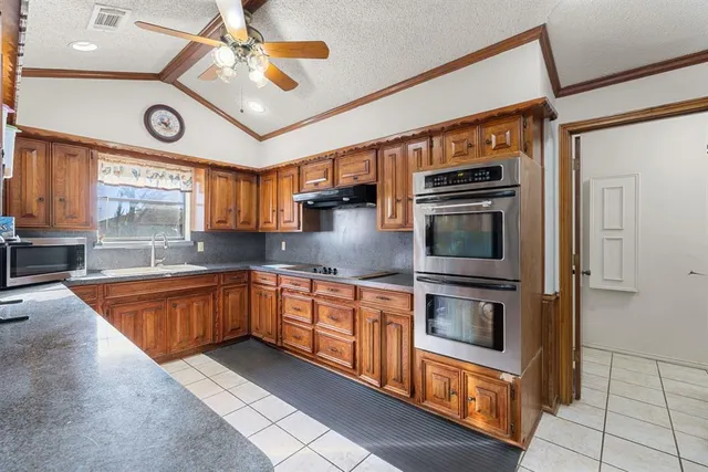 a large kitchen with stainless steel appliances granite countertop a stove and a sink