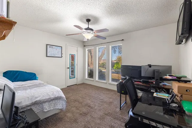 a bedroom with a bed window and a desk