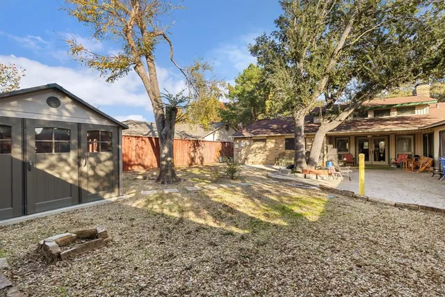 a view of a large house with a yard and wooden fence