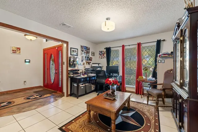 a living room with furniture a flat screen tv and a dining table