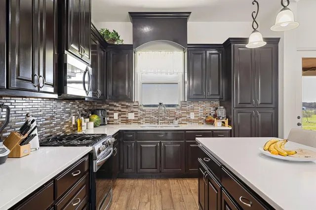 a kitchen with stainless steel appliances granite countertop a sink stove and refrigerator