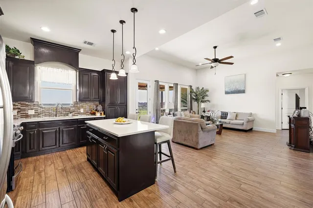 a kitchen with stainless steel appliances granite countertop wooden floors and view living room