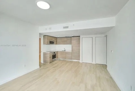 a view of a kitchen with a sink and a refrigerator