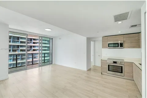a view of an empty room with a fireplace and a window
