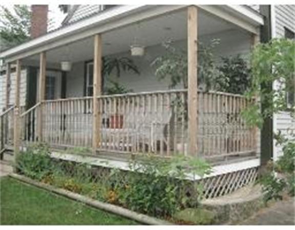 19 Main Street Little Compton, RI 02837 - Photo 4 of 25 a view of a small house with a small yard and wooden fence