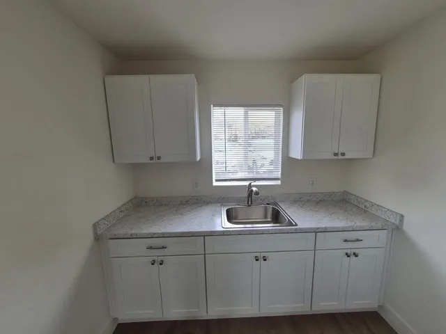 a kitchen with cabinets appliances a sink and a window
