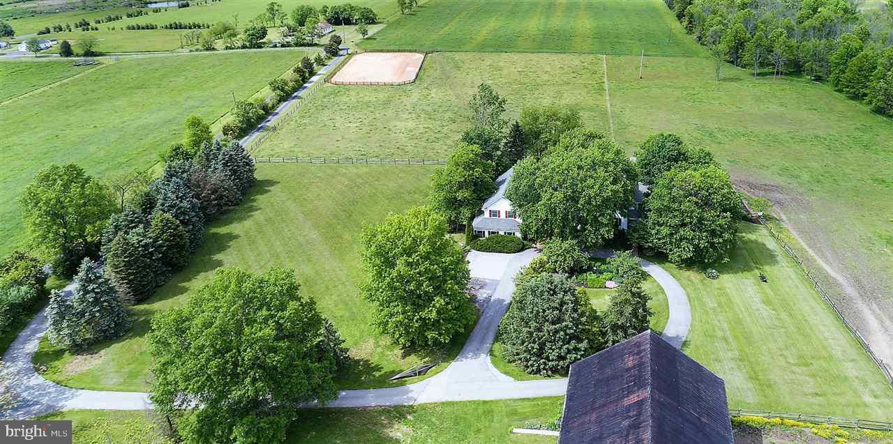 an aerial view of residential houses with outdoor space and trees