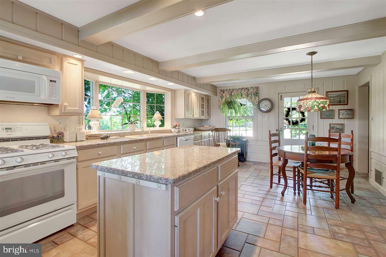 305 Crooked Creek Road Gettysburg, PA 17325 - Photo 14 of 36 a kitchen with a stove a sink a dining table and chairs