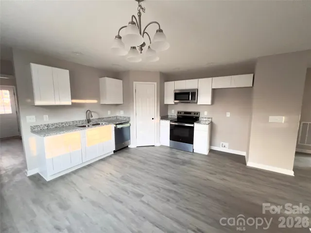a large kitchen with cabinets wooden floor and stainless steel appliances