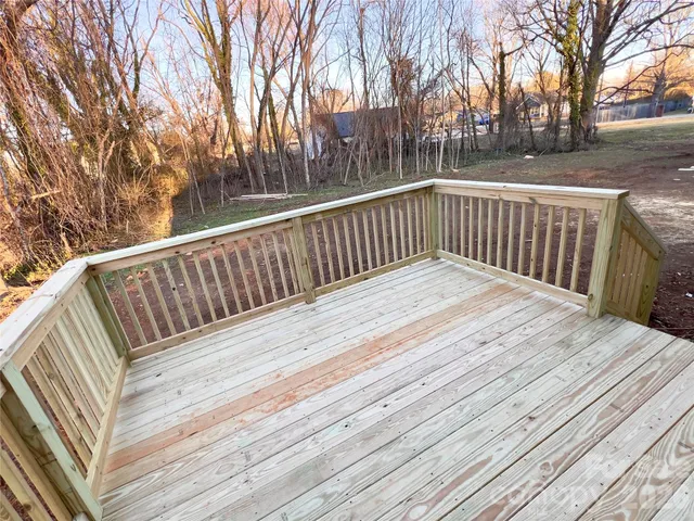 a balcony with wooden floor and trees