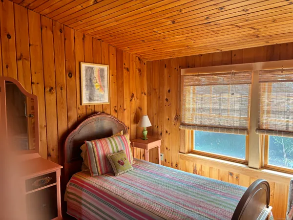 a bedroom with furniture and large windows
