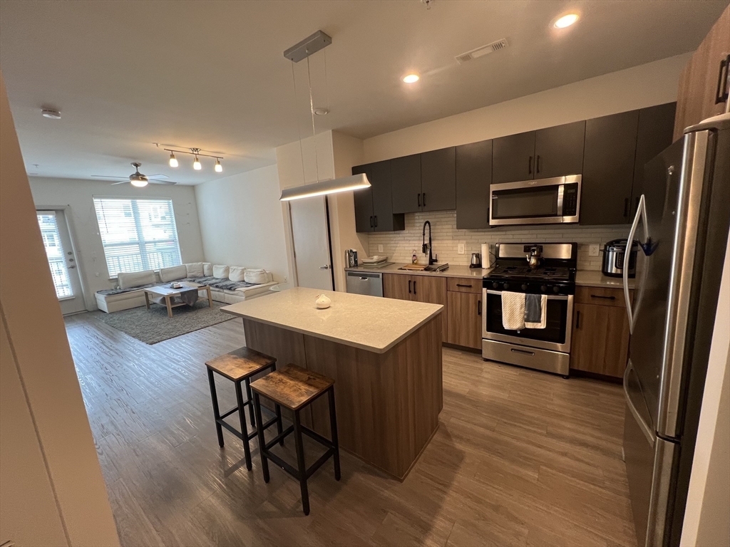 255 Vale Street, Unit 5218 Chelsea, MA 02150 - Photo 3 of 9 a kitchen with a sink a counter top space stainless steel appliances and a window